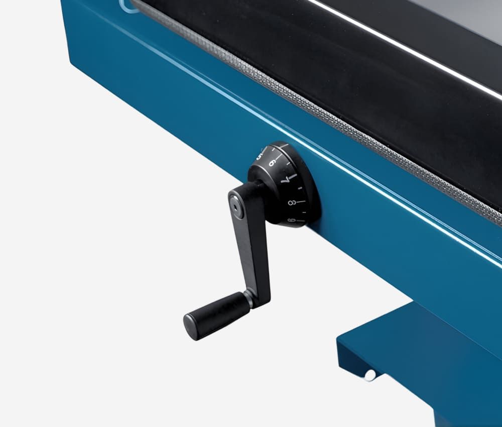 Déplacement de la butée arrière du massicot manuel A3 846 sur stand DAHLE avec la manivelle qui permet un réglage fin au demi-millimètre